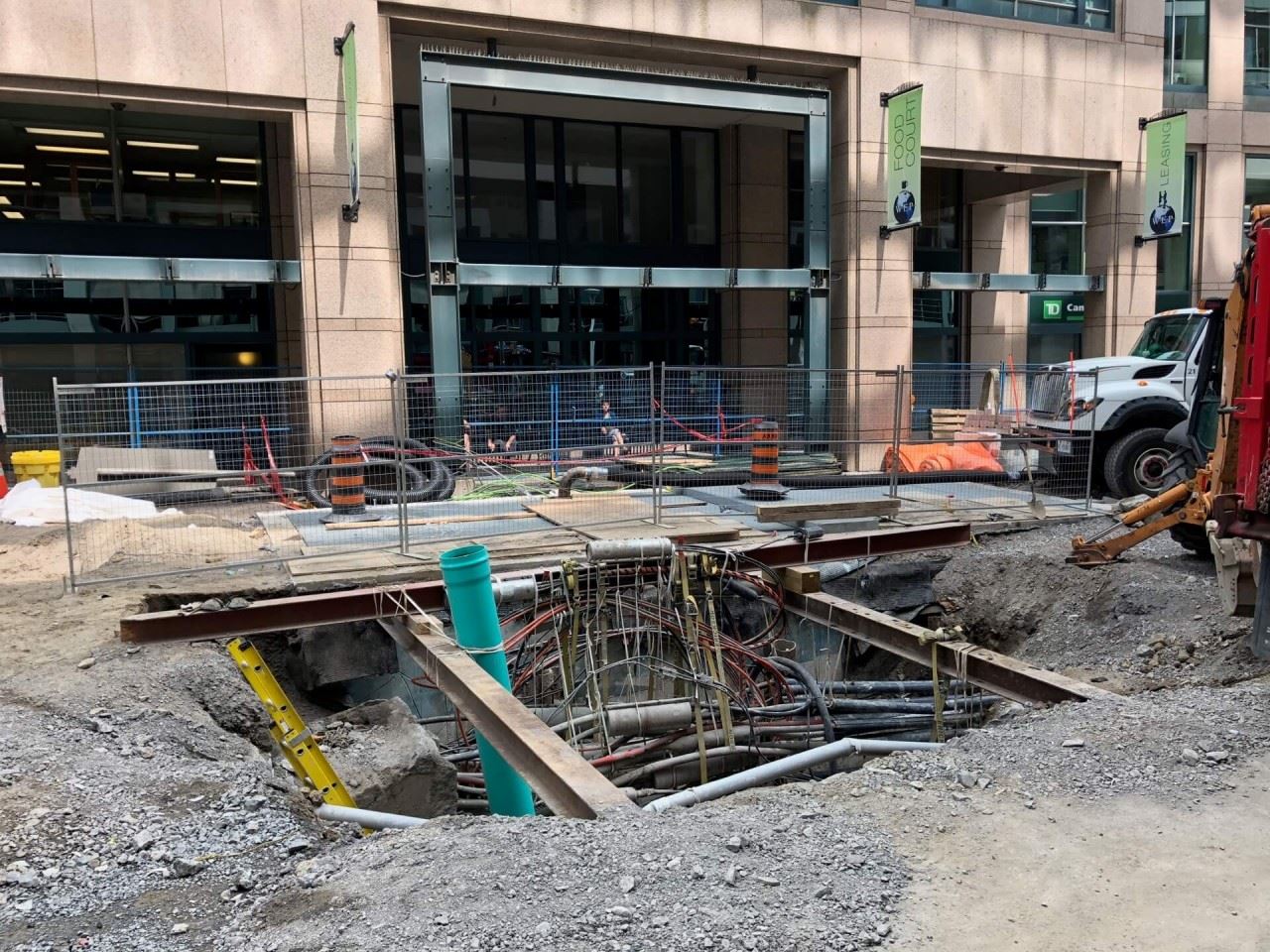 Open work hole on Queen Street, showing exposed wires, conduits and connections.